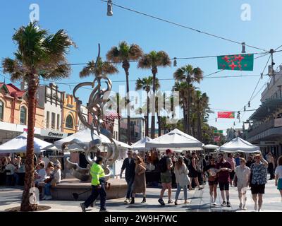 View of people walking through the market stalls and cafes along The Corso in the Sydney suburb of Manly on a bright sunny spring day in November Stock Photo