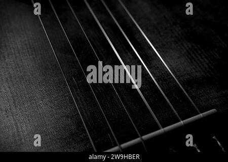 Close Up of Old Classical Guitar Strings and Bridge in Black and White Shadows Light Abstract Stock Photo
