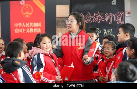 HUAI'AN, CHINA - DECEMBER 28, 2023 - A volunteer lawyer explains the Patriotic Education Law of the People's Republic of China to primary school stude Stock Photo