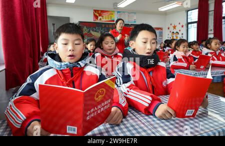 HUAI'AN, CHINA - DECEMBER 28, 2023 - Primary school students read the legal provisions of the Patriotic Education Law of the People's Republic of Chin Stock Photo