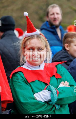 The annual Christmas morning dip into Blackroot Pool in Sutton Coldfield Park. On the stroke of 10am, people dressed in festive costumes, dive, jump, lower themselves into the water. Stock Photo