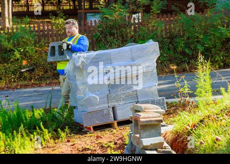 Building retaining walls that are being built by contractor installing concrete block walls Stock Photo