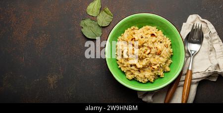 Ven Pongal (Khara Pongal), traditional Indian savoury rice dish made during celebrating Pongal festival, served in bowl top view on concrete rustic Stock Photo