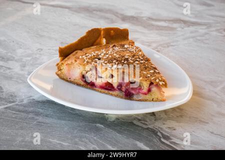 A slice of homemade pie with cherries and plums sprinkled with sesame seeds Stock Photo