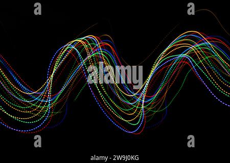 A photograph of vibrant multi-color lights in a long exposure photo. Dotted lines pattern, waves of colour. Light painting photography Stock Photo
