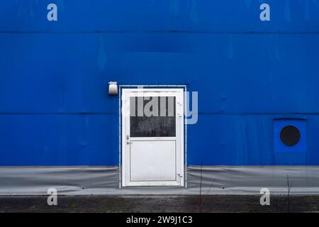 Metal door on blue wall of the sports arena. Stock Photo