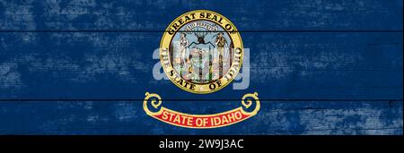 Idaho State flag on a wooden surface. Banner of the grunge Idaho State flag. Stock Photo