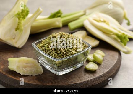 Fennel seeds in bowl and fresh vegetables on table, closeup Stock Photo