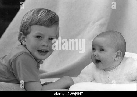 1960s, historical, a little boy with his baby sister, who is looking directly at her brother with eyes and mouth wide-open, England, UK. Stock Photo