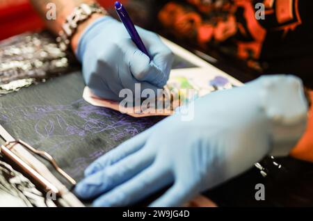 A tattoo artist during work Stock Photo - Alamy