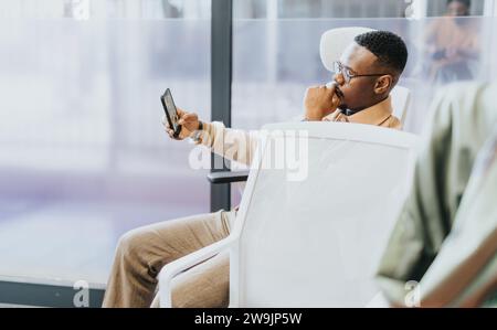 Handsome, black male taking a selfie and having fun at work. Stock Photo