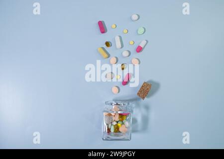 Bottle and scattered pills on color background, top view. Stock Photo