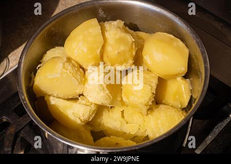 Close up view of cooked potatoes in a pan on a cooker Stock Photo