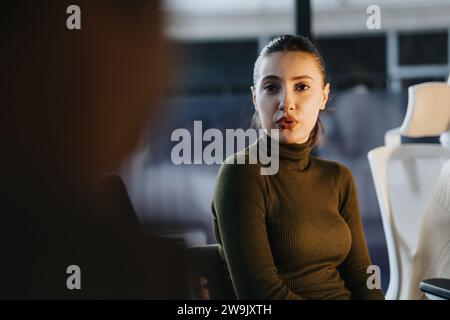 Brunette woman explaining something to her colleague during meeting at the office. Stock Photo