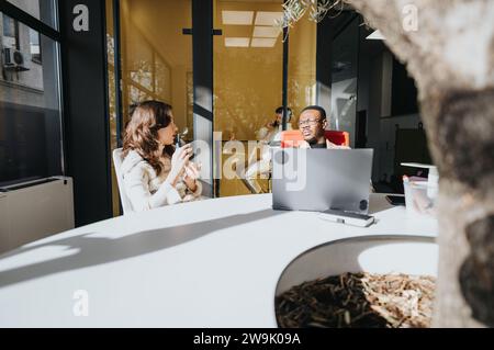 A multiethnic group of business people collaborating on financial planning and market research in a corporate office. Stock Photo