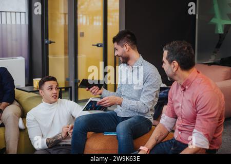 Business colleagues brainstorm and collaborate in a modern co-working space driving productivity and fostering a positive, effective work environment. Stock Photo