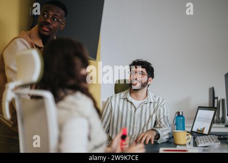 Diverse business professionals collaborate, brainstorm, and analyze statistics in a creative office. Stock Photo