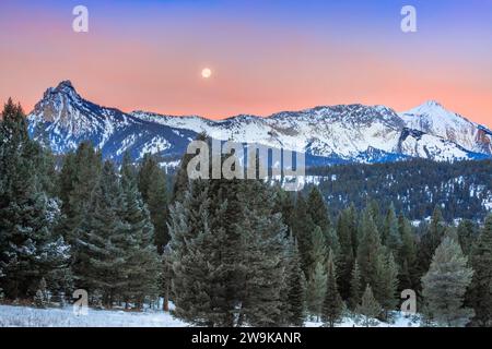 full moon setting in a pre-dawn sky over the bridger mountains near bozeman, montana Stock Photo