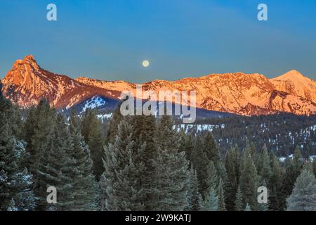 full moon setting at first light over the bridger mountains near bozeman, montana Stock Photo