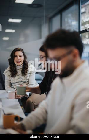 Business team enjoying a pleasant atmosphere while having a conversation over coffee in a modern kitchen. Stock Photo