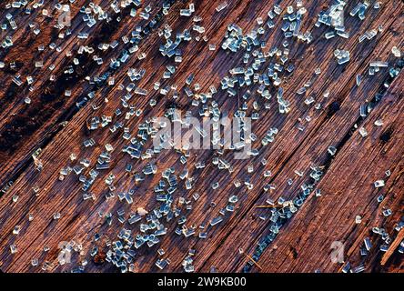 Abstract graphic close-up of broken glass on weathered wood surface Stock Photo
