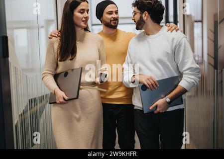 Cheerful businesspeople discussing and strategizing in a corporate office. Corporate employees sharing ideas, working as a team in a co-working space. Stock Photo