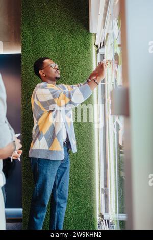 Multiracial professionals collaborate in a modern office, sharing ideas and problem-solving. Stock Photo