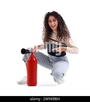 Young African-American woman pointing at fire extinguisher on white background Stock Photo