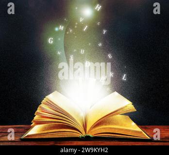 Open book with magic light and glowing letters flying out of it on wooden table against black background Stock Photo