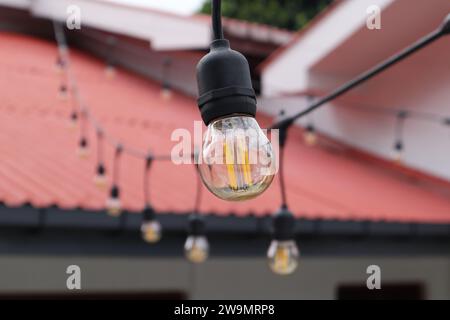 A small globe shaped Edison style LED bulb which has orange color filaments and clear amber glass. This is an outdoor decoration string bulb Stock Photo