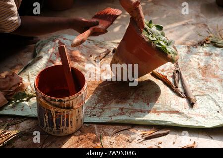 Close-up of an Indian gardener repainting plant pots in preparation for Diwali, New Delhi, India Stock Photo