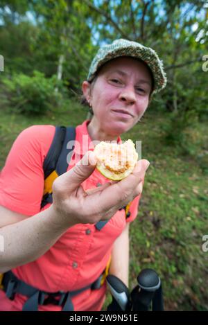 A woman enjoys a fresh guava picked from a tree in the French Quarter on Segment 1 of the Waitukubuli National Trail on the Caribbean island of Dominica. Stock Photo
