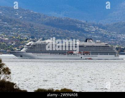 Viking Orion passenger cruise ship in profile or side on, departing Hobart, Tasmania along the Derwent River 12/28/2023. Whole ship with Sandy Bay and Stock Photo