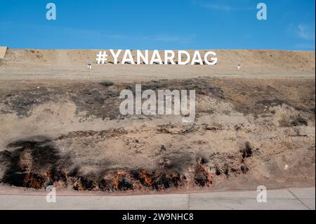 Yanar Dagh sign on  a hillside in Absheron Peninsula near Baku, capital of Azerbaijan. Natural gas escapes from the rock and burns. Stock Photo