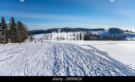 Panoramic winter landscape at Severak ski resort and many cross country skiers in Hrabetice, Jizera Mountains, Czechia Stock Photo