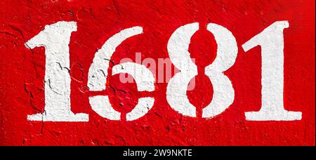 Weathered numbers one, six, eight, 1681, or 1, 6, 1 painted white on a piece of red metal. Abstarct numeral background for design. Stock Photo