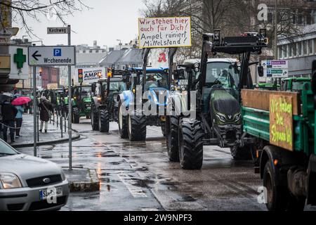 Siegen, Germany. 29th Dec, 2023. Numerous tractors drive along a road in the center of Siegen. With a convoy of several hundred tractors, farmers in the Siegen area protested against the savings plans of the traffic light coalition on Friday. Credit: Christian Knieps/dpa/Alamy Live News Stock Photo