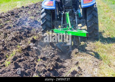 Farmer in tractor preparing land to spring season for sowing Stock Photo