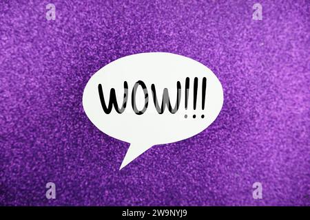WOW!!! text message in white bubble speech top view on purple background Stock Photo