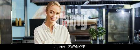 joyful blonde businesswoman smiling at camera in modern cafe, small business, horizontal banner Stock Photo