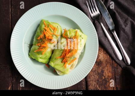Cabbage rolls stuffed with meat on plate over green background. Top view, flat lay . Stock Photo