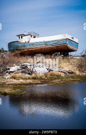 Abandoned wooden fishing boat slowly rotting away on the Eastern Shore of Nova Scotia, Canada. Stock Photo