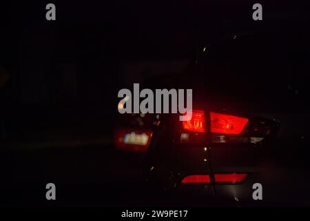 Taillights shining bright in the night traffic, a mesmerizing scene of urban motion. Stock Photo