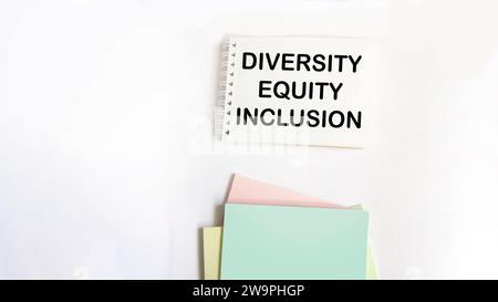 Diversity, equity, inclusion DEI symbol. On the notepad are the words DEI, diversity, equity, inclusion. White background. Stock Photo