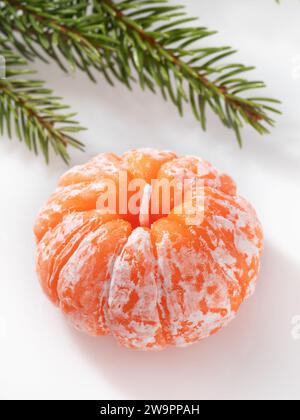 Fir branch and aromatic candle in the shape of a tangerine on a light background Stock Photo