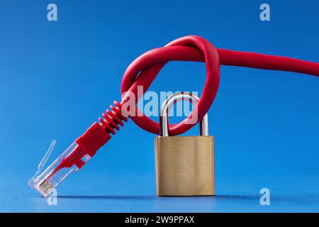 Lock and knotted computer network wire on a blue background Stock Photo