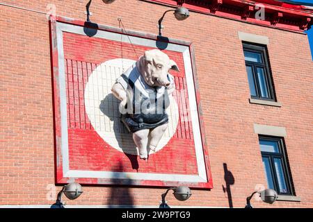 Sculpture of a pig wearing a black apron sign at a butcher shop in downtown Montreal, Quebec, Canada Stock Photo