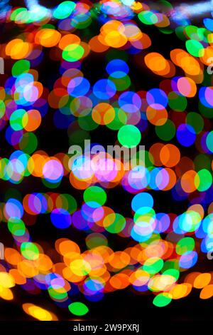 Large vibrant green, red, orange and blue bokeh balls swirling and creating magical ornament. Abstract high resolution background. Vertical. Real phot Stock Photo