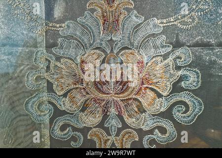 The detailed texture of an antique lace curtain hanging in a window Stock Photo
