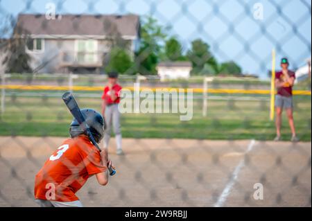 Parent view behind a chain link fence and home plate with a batter ready Stock Photo